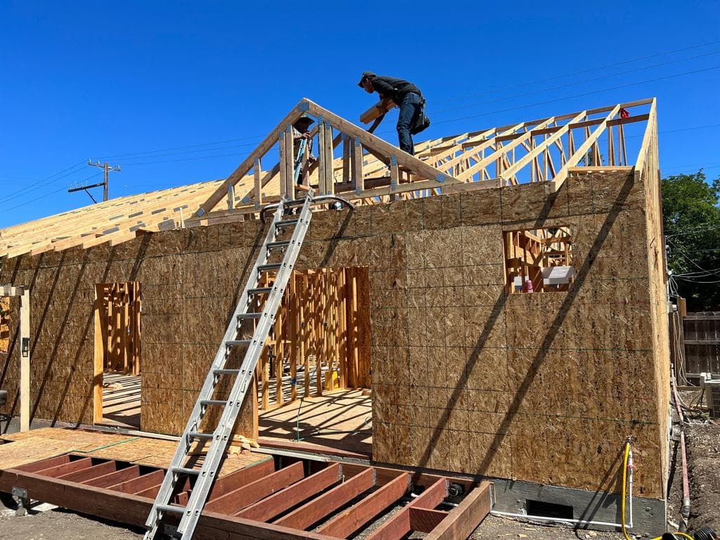 Crew setting roof framing on a new home