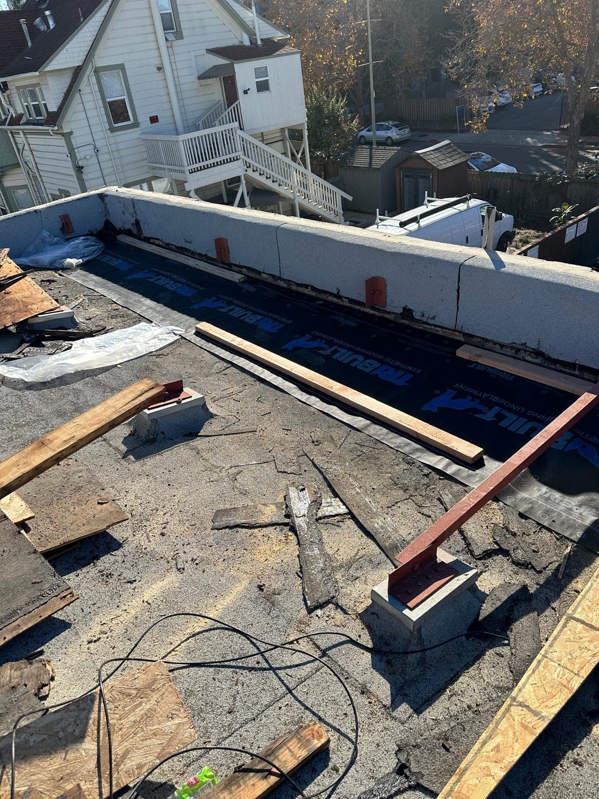 Flat roof tear-off with new synthetic underlayment along the parapet