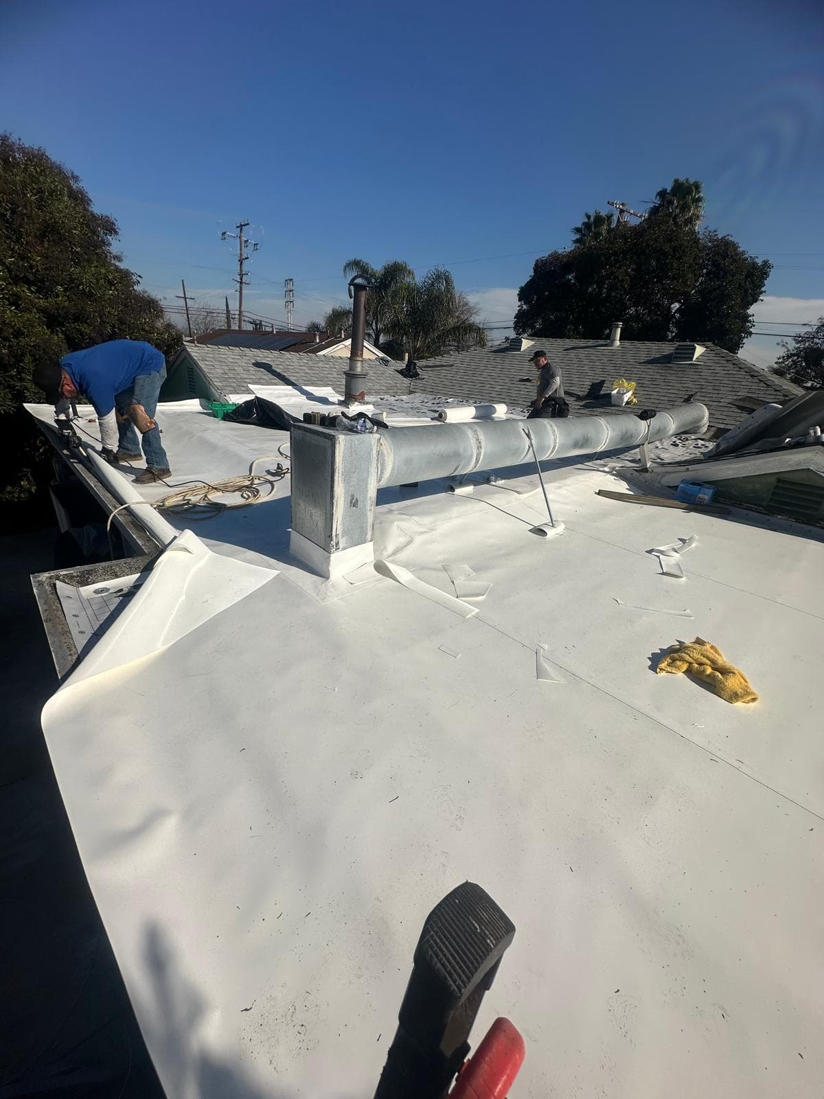 White TPO membrane being installed on a low-slope roof